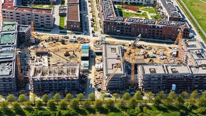 Fototapeta premium Large construction site in Germany featuring multiple cranes and excavators actively working on a major residential and commercial development project. 