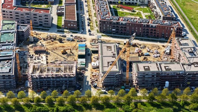 Large construction site in Germany featuring multiple cranes and excavators actively working on a major residential and commercial development project. 