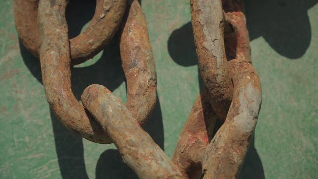 Corroded metal links. Zoomedin view of oxidized and corroded metal links in detail. Close examination of heavily rusted and deteriorated metal chain links with intricate corrosion patterns
