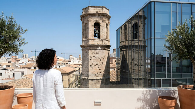 Mujer joven mirando el campanario de la Concatedral de San Nicol&aacute;s y la arquitectura moderna en Alicante, Espa&ntilde;a