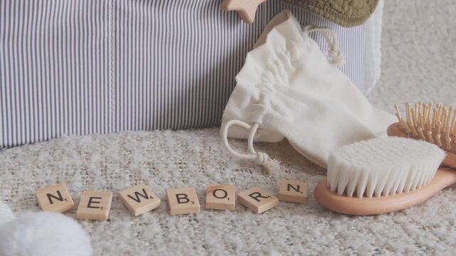 Set of newborn accessories with wooden brushes and toys on a soft blanket