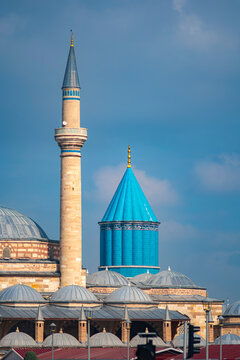 Architectural shot of the turquoise Green Dome and minaret at the Mevlana Museum in Konya, Turkey. The historic 13th-century pilgrimage site showcases Seljuk heritage under a bright blue sky.