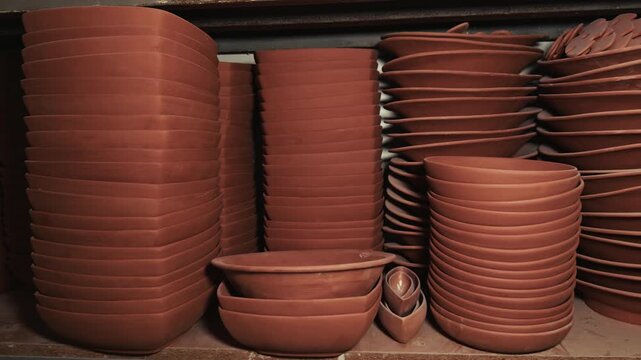 Artisan Clay Dishes and Bowls Piled High in a Workshop