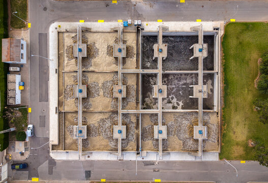Overhead view of activated sludge aeration tanks in a wastewater treatment facility showing biological water treatment process with multiple aerated compartments and blue aerators