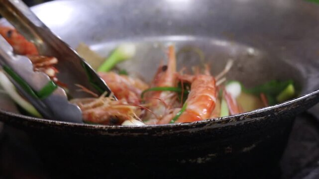 Chef Stir-Frying Large Prawns with Spring Onions in a Wok over an Open Flame for Baked Prawn with Glass Noodles