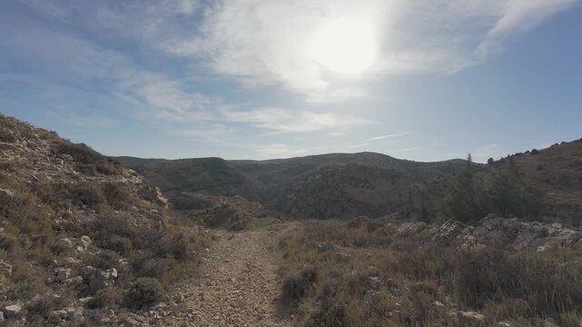 Point of view hiking on a mountain trail during a sunny day