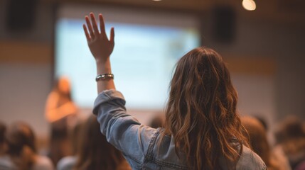Fototapeta premium A student raising her hand to ask a question during a lecture or seminar