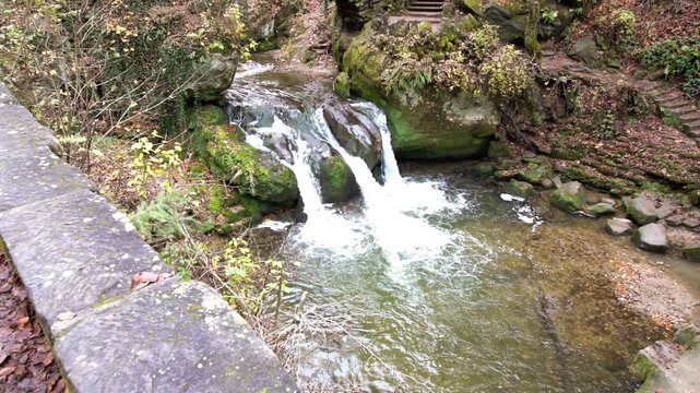 deep in the forest there is a small waterfall in switzerland in Luxembourg