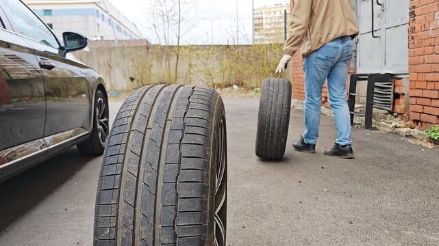 Two summer tires standing upright on the asphalt. Seasonal tire changes, car preparation, and car storage.