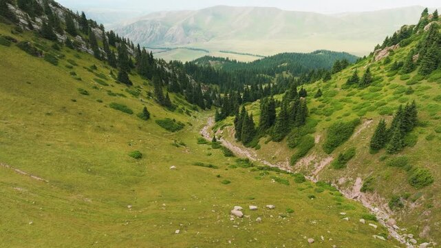 Flying along a beautiful gorge South East of Karakol in Kyrgyzstan in summer.