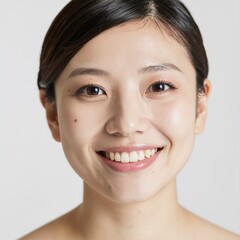 Obraz premium Portrait de face d'une jeune femme asiatique souriante avec une peau parfaite