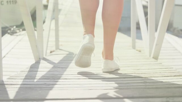 Female teen initiating walk on sunlit dock, animated step count showing sneaker stride for travel