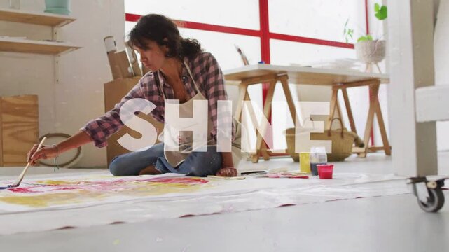 Sun flare arcing frame sparking SHINE overlay while woman artist painting canvas, making bright art