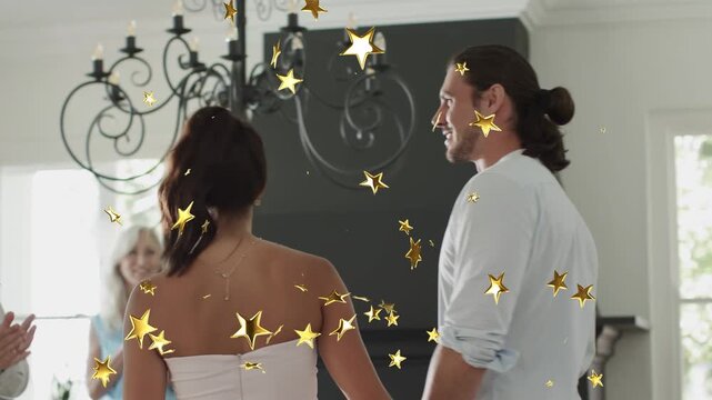 Guests clapping, couple walking in under gold stars, woman waving while man guiding for events