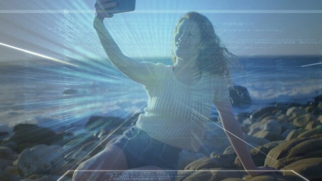 Woman posing on rocks raising phone while checking screen with glitches amplifying for social media