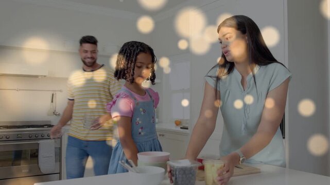Woman placing tubs at island, child reaching, man arranging bowls and berry box, doing food prep