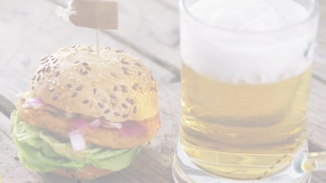 Camera shifting left, revealing seeded-bun burger with skewer, fries appearing, beer showing meal