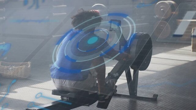 Man initiating stroke, rowing on rower while blue HUD overlaying subject and tracking fitness