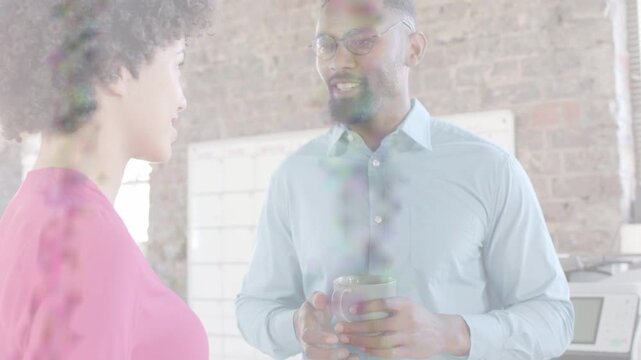 Man initiating office chat, gesturing, woman nodding, holding spoon and mugs, overlays appearing