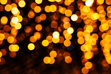 Colorful bokeh lights create a warm atmosphere in a festive setting during an evening event in the city square © ir1ska