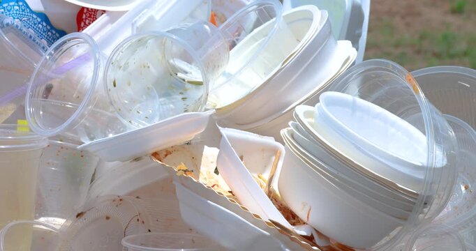 Plastic waste pile including cups and foam containers, Garbage pile, Plastic waste, Pollution, Waste management issues, and environmental impact, close-up