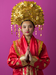 Naklejka premium Young Indonesian Asian Girl Wearing Ornate Gold Headdress and Traditional Red Chinese Costume Portrait
