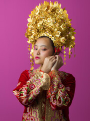 Naklejka premium Traditional Gold Bridal Headdress and Embroidered Red Costume Portrait of Young Asian Bride