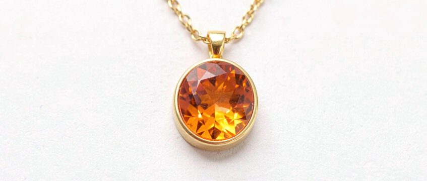 A beautiful gold necklace featuring a large orange stone, perfect for everyday wear or as a statement piece