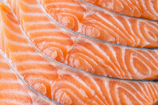 Raw salmon slices pattern close up fresh fish texture background