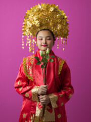 Naklejka premium Serene Young Bride in Traditional Red and Gold Wedding Headdress Holding White Roses