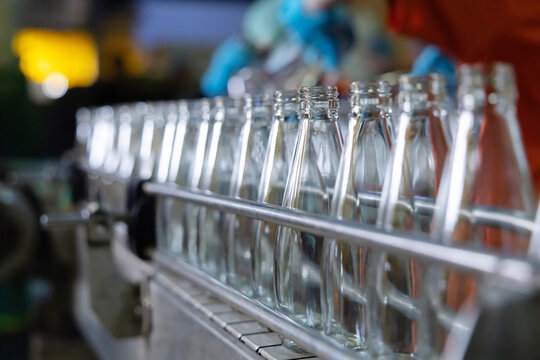 Glass bottles on a conveyor belt in a factory