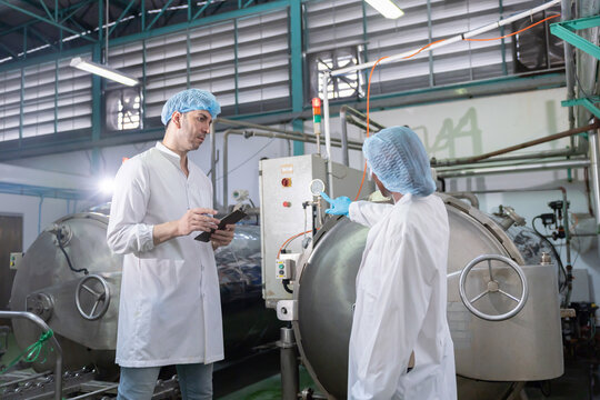 Workers discuss process in boiler room in a factory
