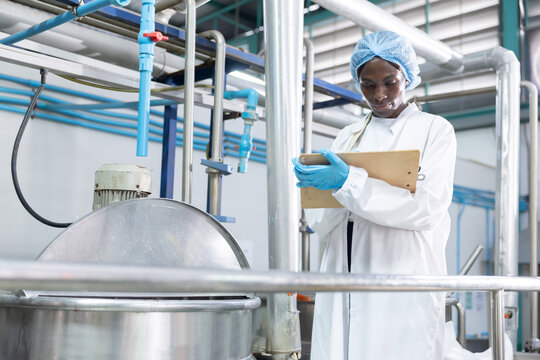 Black worker checksthe boiling process in food processing area
