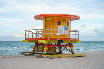 Iconic yellow lifeguard station on the Atlantic Ocean shore. Traditional colorful rescue tower on Miami Beach sand with ocean background under a bright sky. © Vadim
