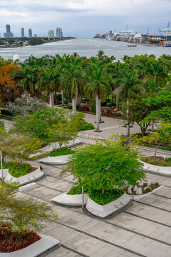 Modern park design with planters and palm trees in Miami. Maurice A. Ferre Park featuring white geometric planters, palm trees, and the PortMiami channel.