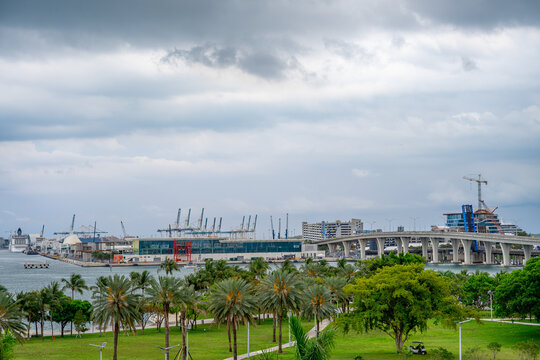 MacArthur Causeway bridge and PortMiami gantry cranes in Florida. View of the bridge connecting Miami to the port with industrial cranes and palm trees.