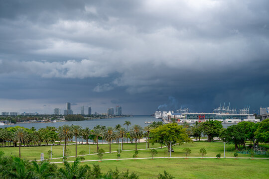 Dramatic storm front approaching Port of Miami waterfront. Dark rain clouds covering the sky over Biscayne Bay with cruise terminal and city skyline in the distance.