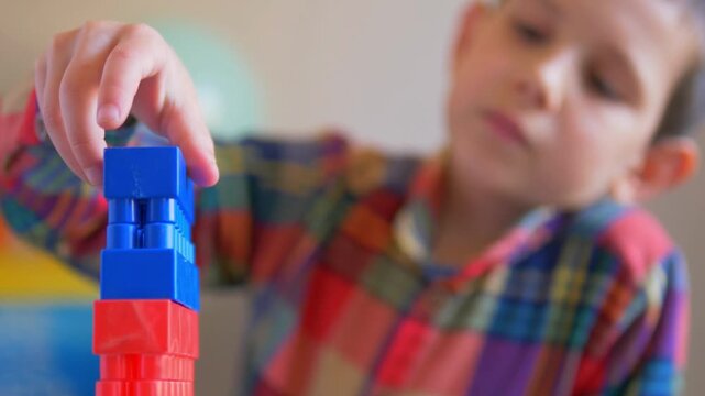 Focused Boy Balancing Plastic Building Blocks &mdash; Close-Up Video of Child Constructing Colorful Toy Tower, STEM Learning, and Fine Motor Skill Coordination
