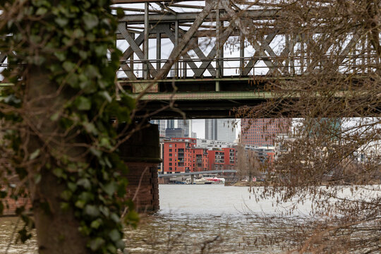 Hochwasser unter alter Eisenbahnbr&uuml;cke mit &uuml;berfluteter Stra&szlig;e in st&auml;dtischer Umgebung