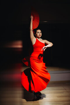 Flamenco dancer performing with red fan