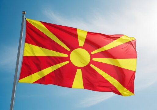 Flag of north macedonia waving against a clear blue sky