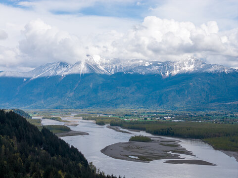 Snow-Capped Mountains and Meandering River Under Dramatic Clouds Near Harrison Mills in Fraser Valley, British Columbia