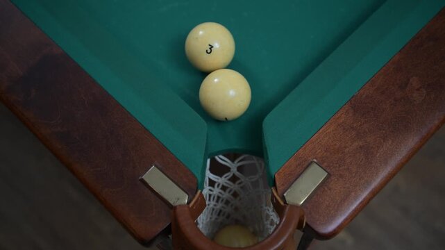 Rolling the ball with the lucky number 7 into the hole of the billiard table during the game