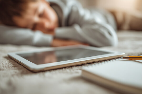 Sleeping boy with tablet after studying and playing