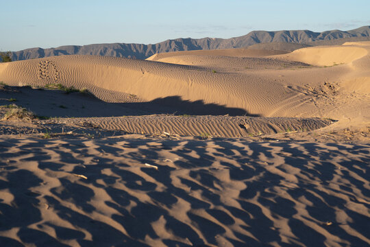 paisaje de desierto con dunas y monta&ntilde;as al atardecer