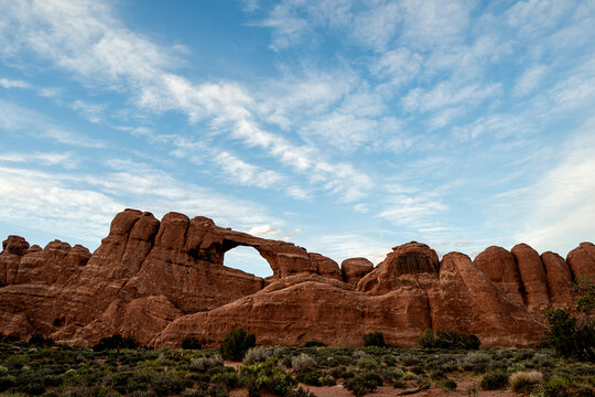 North Window Arch in Arches National Park under blue sky with scattered clouds