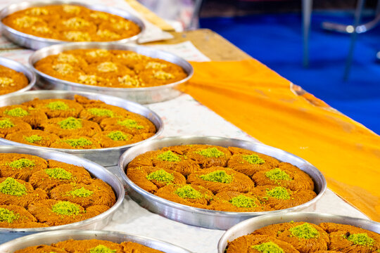 Turkish traditional dessert in various flavors. Pieces of turkish traditional declious dessert pohlava with nuts and honey. Turkish sweets. Turkish Burma Kadayif with Pistachio Powder in Tray Dessert 