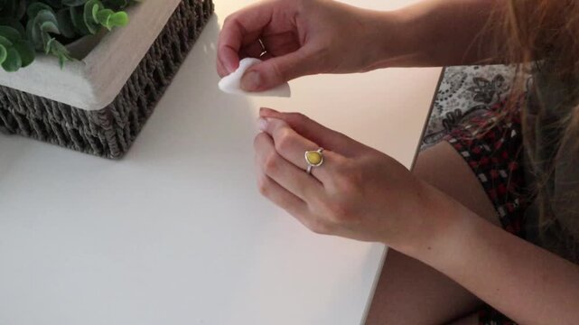 Woman holding cotton pad after removing nail polish at home. Personal beauty routine for manicure care, hand grooming, cleanup process and domestic self care concept.