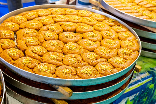 Turkish traditional dessert in various flavors. Pieces of turkish traditional declious dessert pohlava with nuts and honey. Turkish sweets. Turkish Burma Kadayif with Pistachio Powder in Tray Dessert 