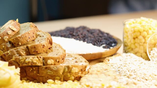 Healthy grains and food items slowly falling into a bowl and displayed on a wooden table, featuring whole wheat bread and other nutritious elements.
